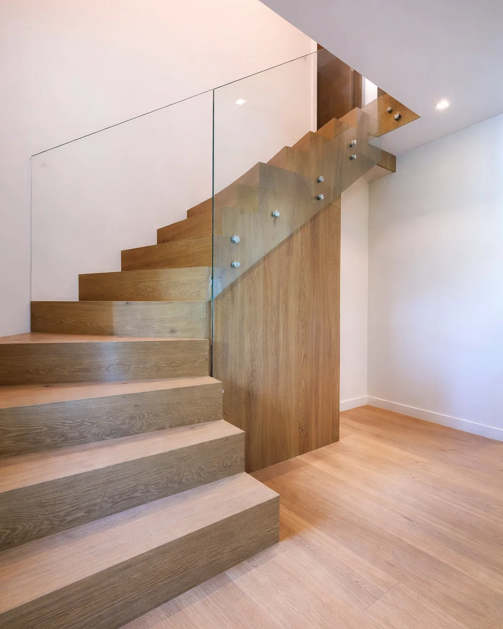 Escalier en bois posé par Renova Swiss, garde-corps en verre