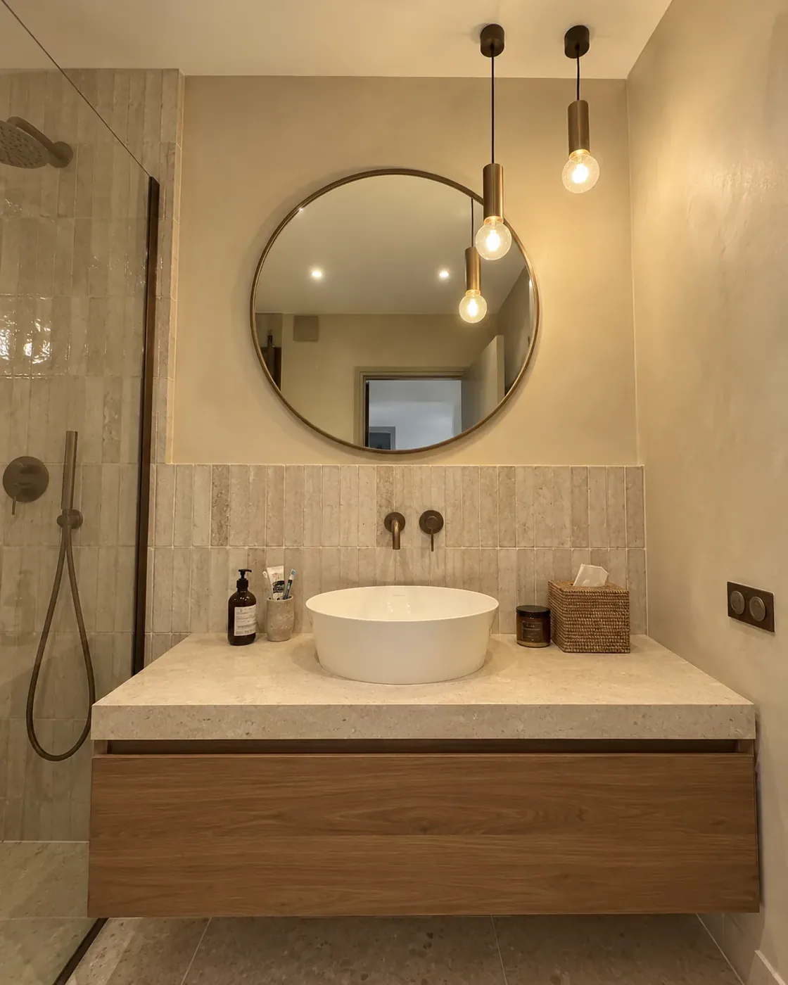 Salle de bain d'appartement, vasque posée et miroir rond