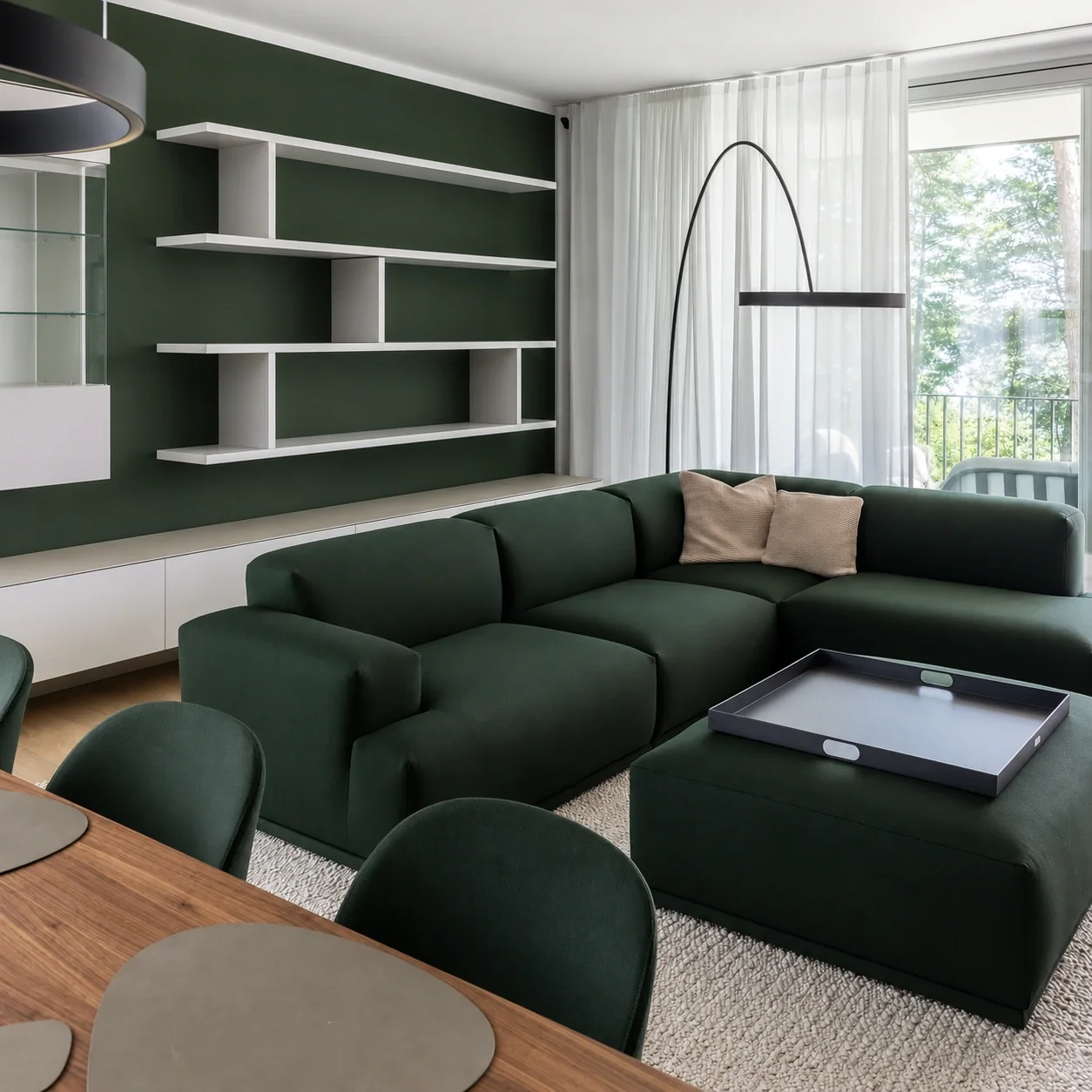Salon de maison, mur peint vert et bibliothèque sur mesure